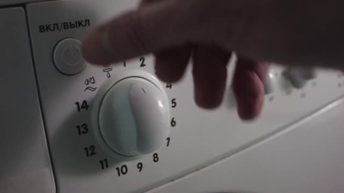 一个年轻女子晚上在家用洗衣机洗衣服。