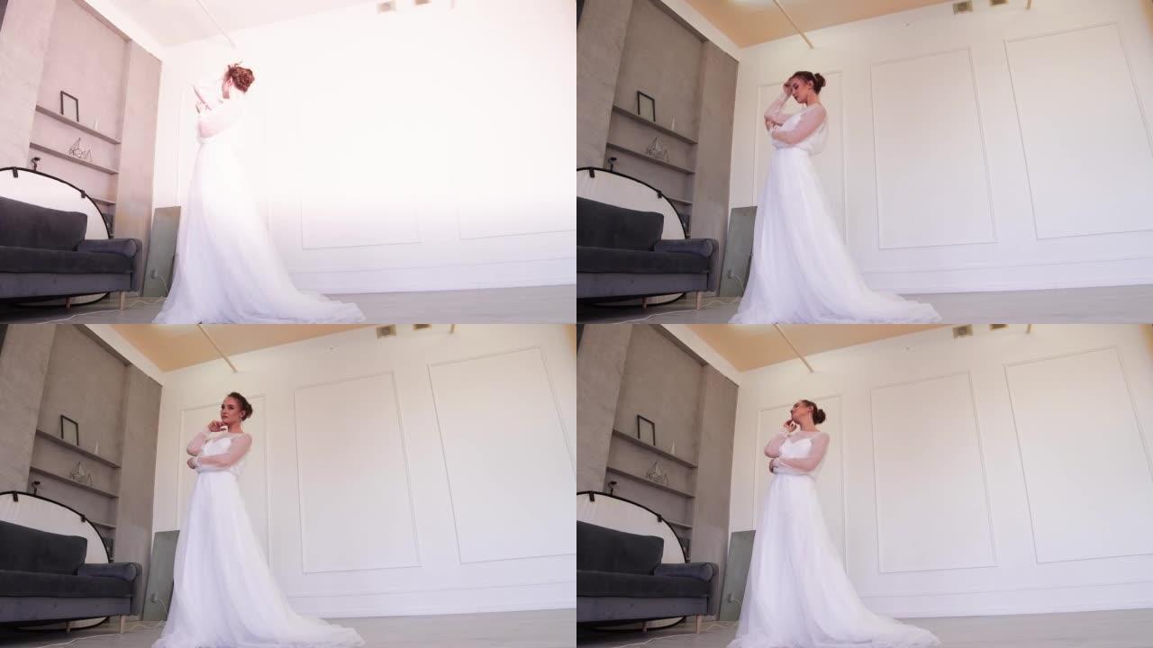 一位穿着白色连衣裙的年轻新娘站着为摄影师摆姿势。