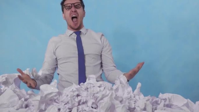 怒火中烧的办公室职员斜靠在一大堆皱巴巴的纸上，背景是蓝色的