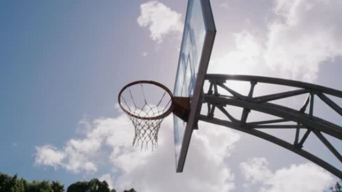 篮球场上的篮筐仰视图。空篮球网在天空背景下的低角度