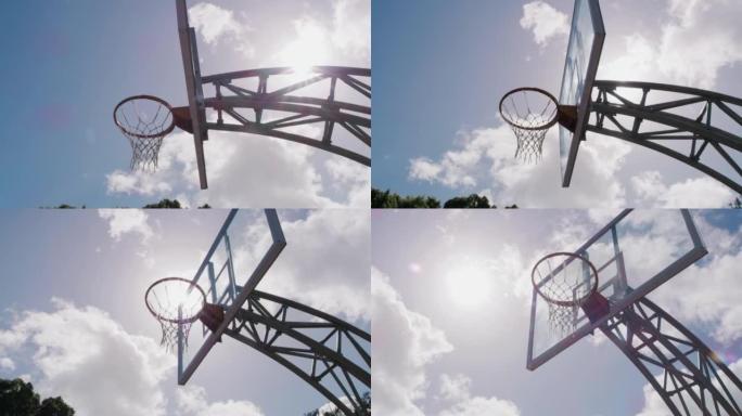 篮球场上的篮筐仰视图。空篮球网在天空背景下的低角度