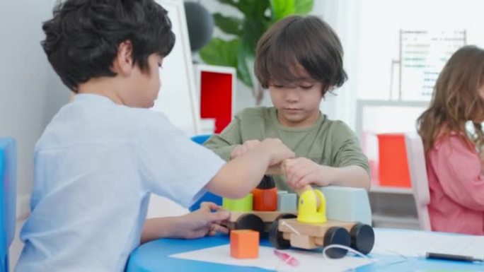 幼儿学生在学校一起玩耍的混血群体。幼儿园的小女孩和小男孩朋友在幼儿园课间休息时花时间玩玩具时感到快乐