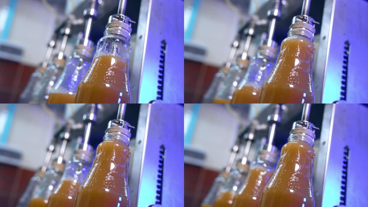很少有玻璃瓶装满新鲜的果汁。果汁制造的自动化工艺流程。特写。
