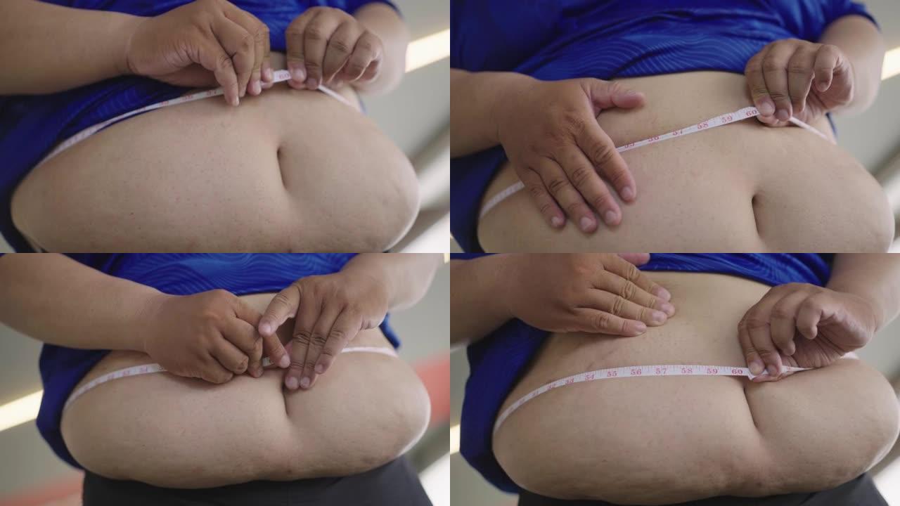 用卷尺测量腰部并轻拍腹部的超重男子的腹部特写。