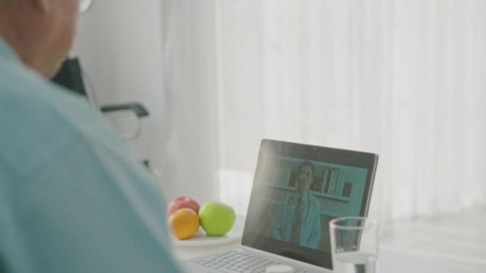 高级夫妇病人在家里用数字平板电脑与男性医生交谈