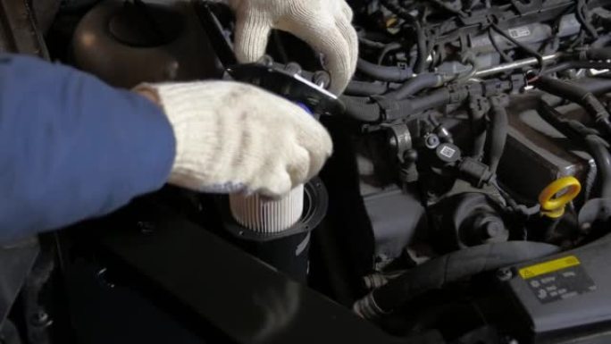 汽车修理工在汽车上安装了新的燃油滤清器。燃油滤清器更换和燃油系统维护