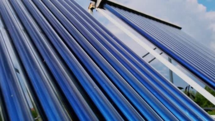 真空集热器是房屋附近的太阳能热水系统。高楼屋顶上的太阳能热水器机组锅炉。蓝天背景与云彩。太阳能热水系