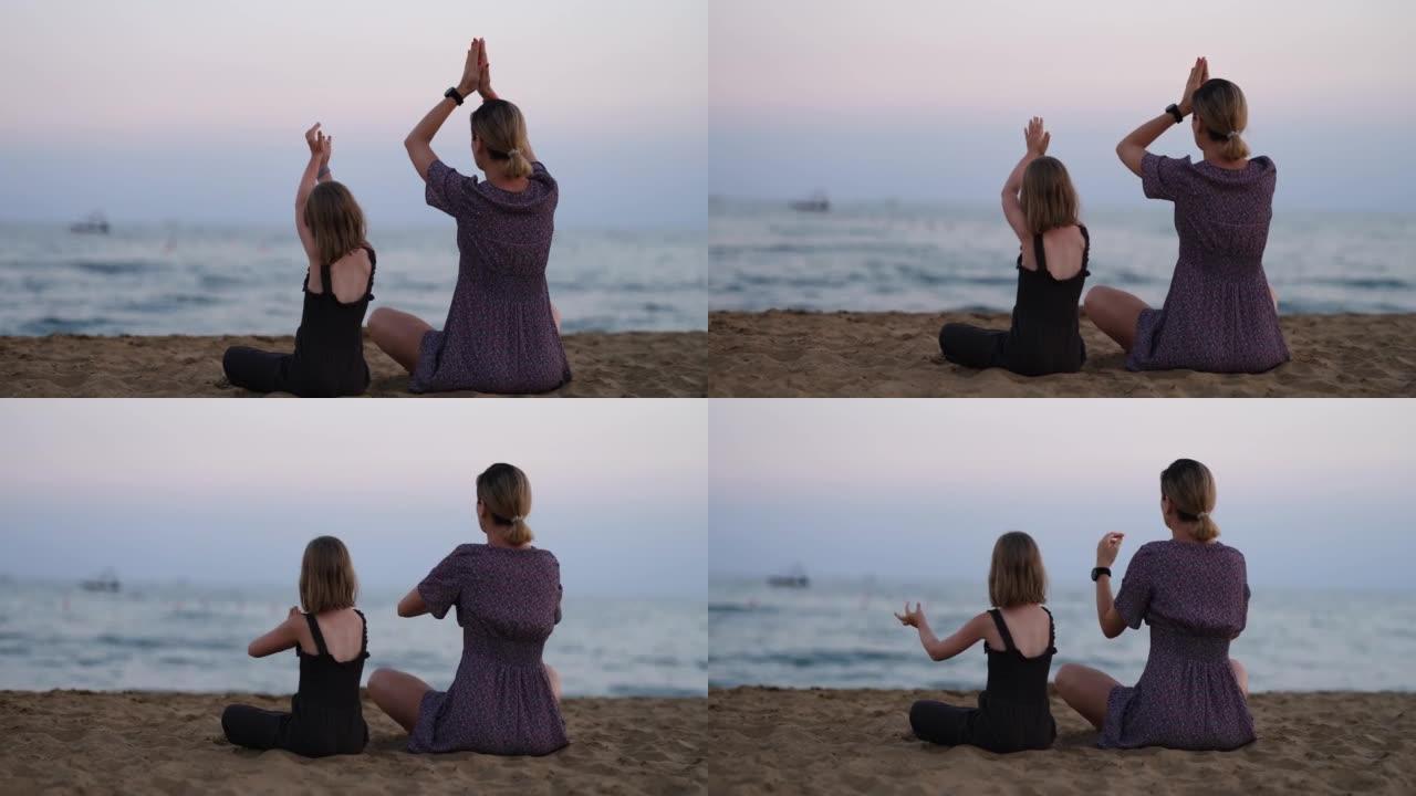 母女在海边做瑜伽的剪影