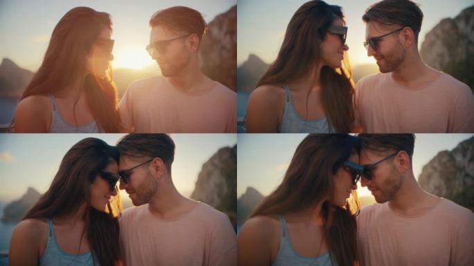 浪漫的夏天。夫妇在度假时戴着墨镜坐在长凳上，背景是金色的日落。爱的拥抱