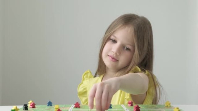 小女孩玩五颜六色的人物。棋盘游戏和儿童休闲概念