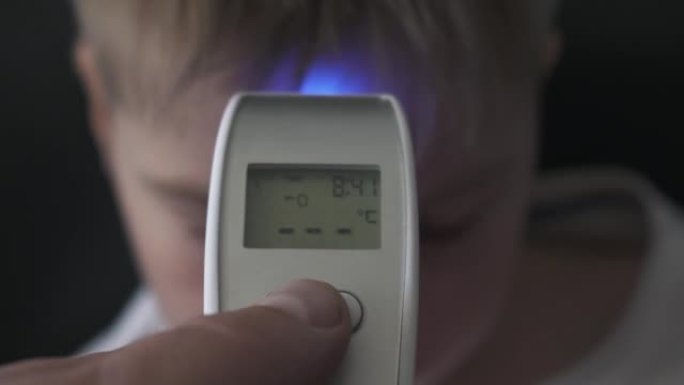 爸爸用数字温度计给儿子量体温Covid 19病毒症状-流行病冠状病毒爆发概念。特写4k镜头