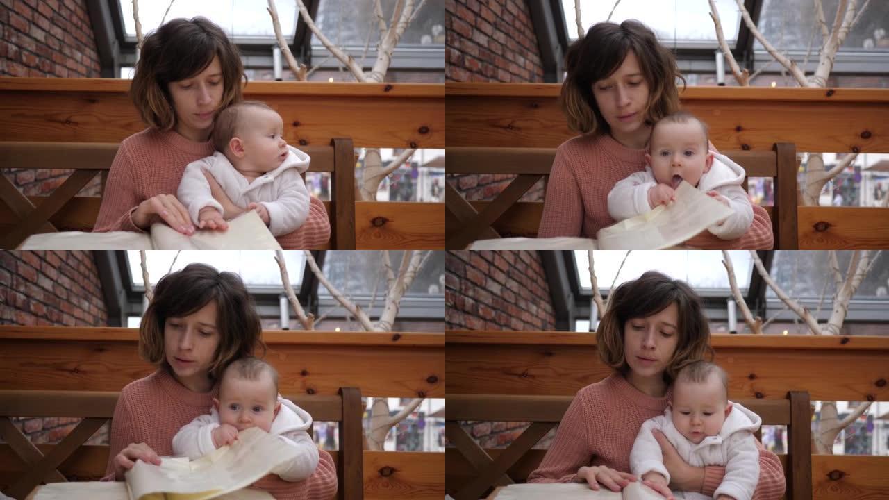 母亲在餐厅里带着婴儿翻阅菜单孩子放进嘴里纸角用舌头好奇的认知