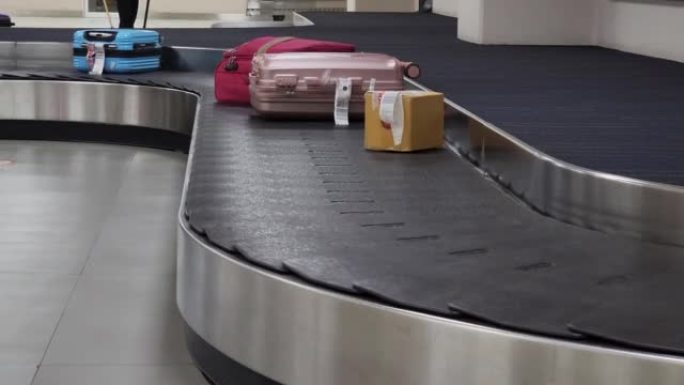 在机场行李认领区的旋转木马上移动的旅行袋热
