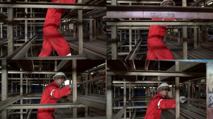 金属工业-一名亚洲工人在仓库中移动球墨铸铁管的垂直平移镜头