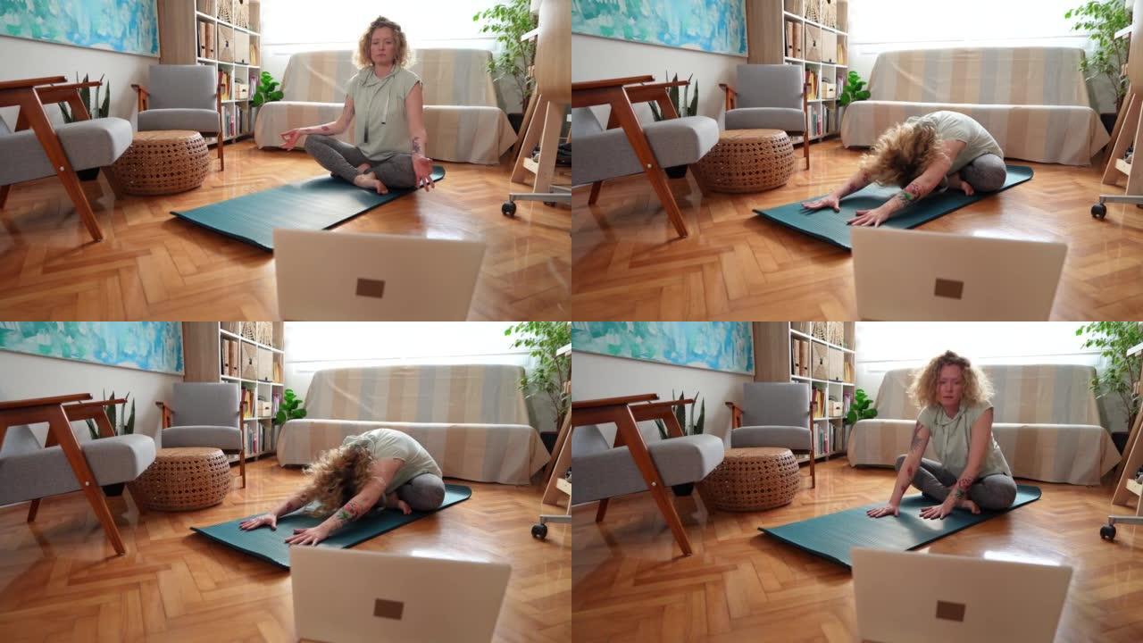 女人在笔记本电脑上进行在线瑜伽课，同时在家锻炼