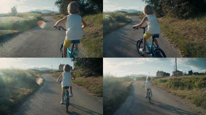 暑假无忧无虑的孩子在村里的农田骑自行车