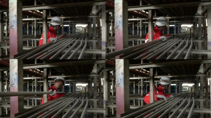 金属工业-在仓库中移动球墨铸铁管的工人