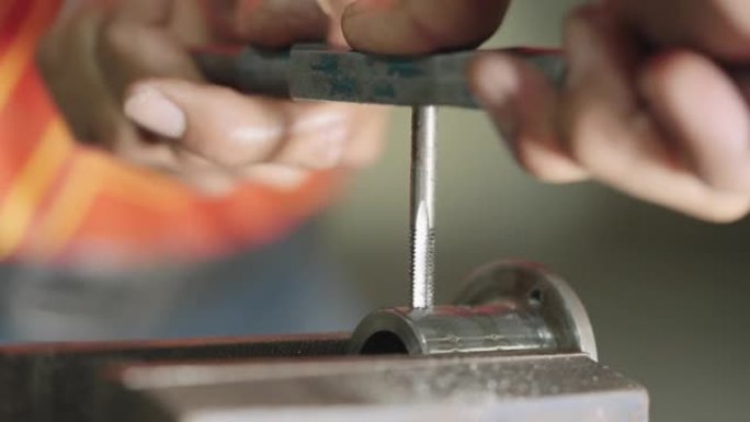 特写一名员工正在工厂使用钢制车刀。