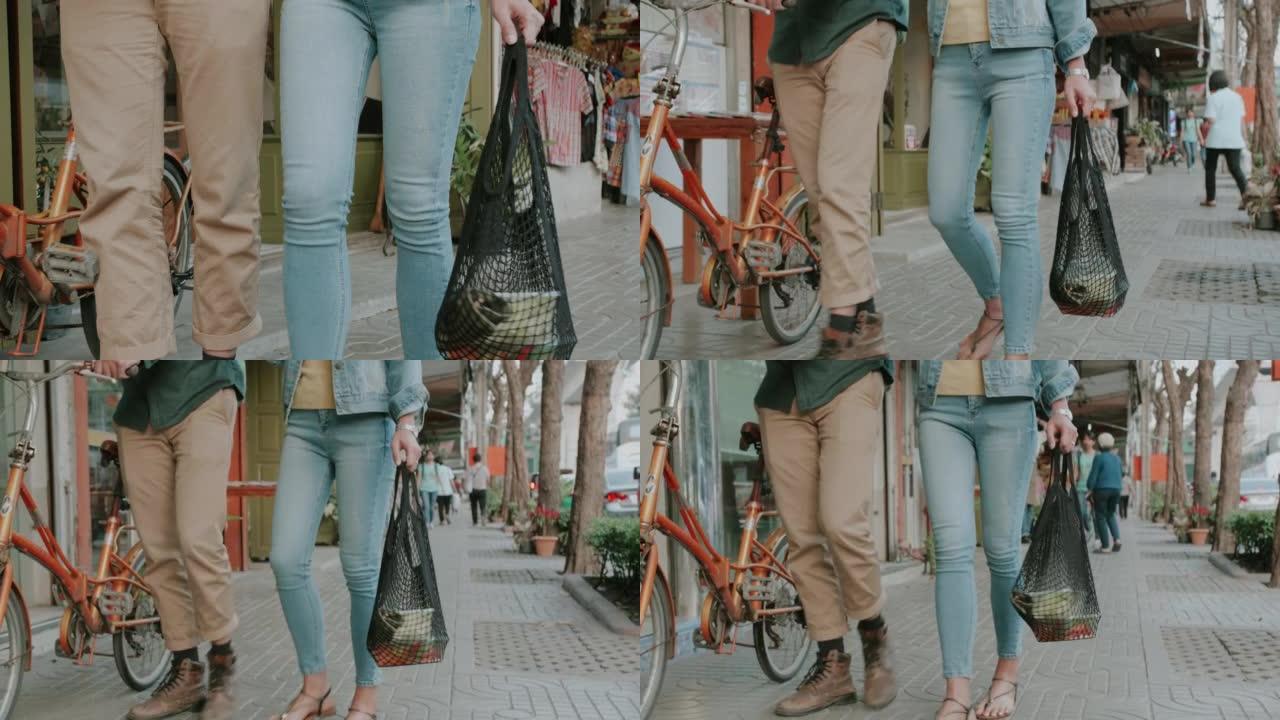 与泰国时髦夫妇一起使用可重复使用的购物袋进行杂货购物，走向绿色。