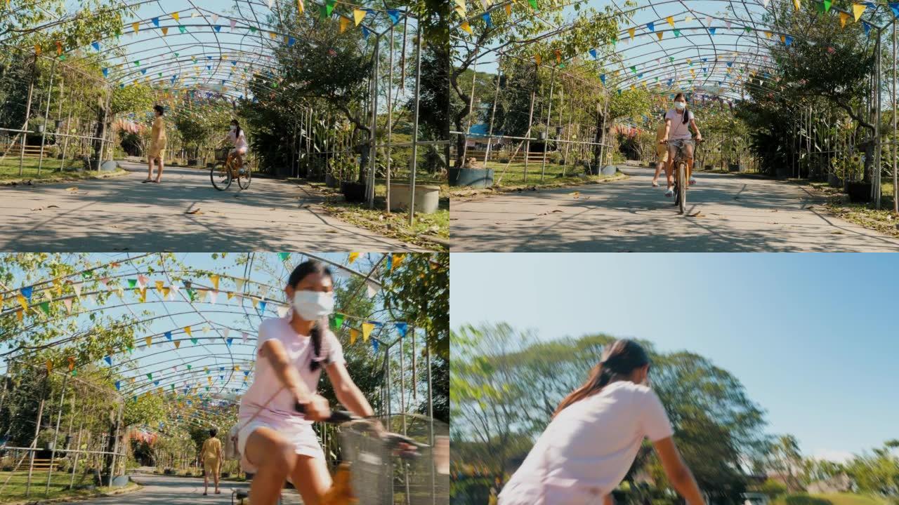 亚洲女孩在乡下骑自行车，看着风景，生活方式的概念。