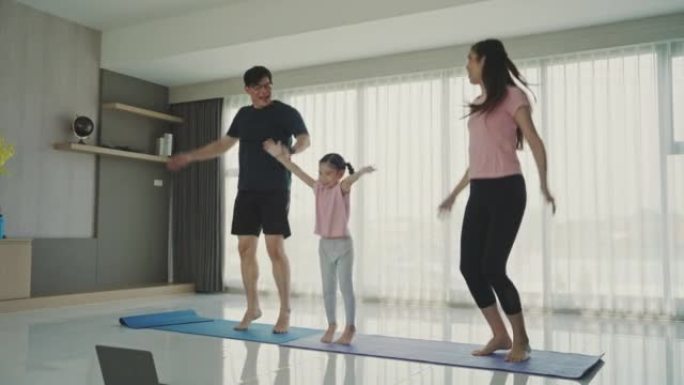 亚洲年轻家庭训练在家里的客厅。