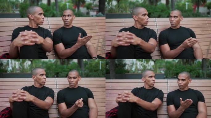 Two confident bald brothers talking while sitting 