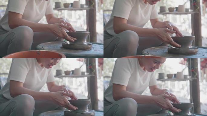 亚洲女性黏土艺术家在她的工作室里用旋转的陶器轮工作