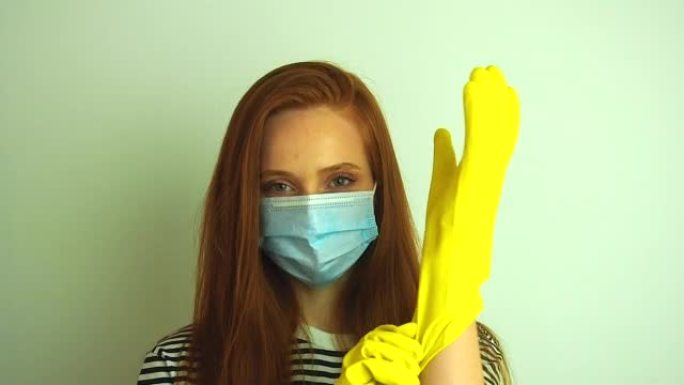 年轻女子戴着白色防护口罩，戴上医用手套，为冠状病毒疫情做准备。