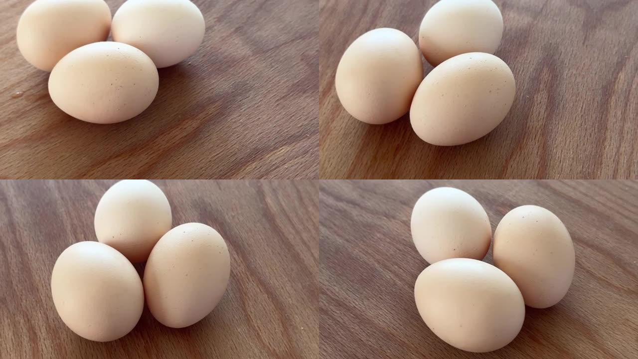 三个鸡蛋在木桌上旋转