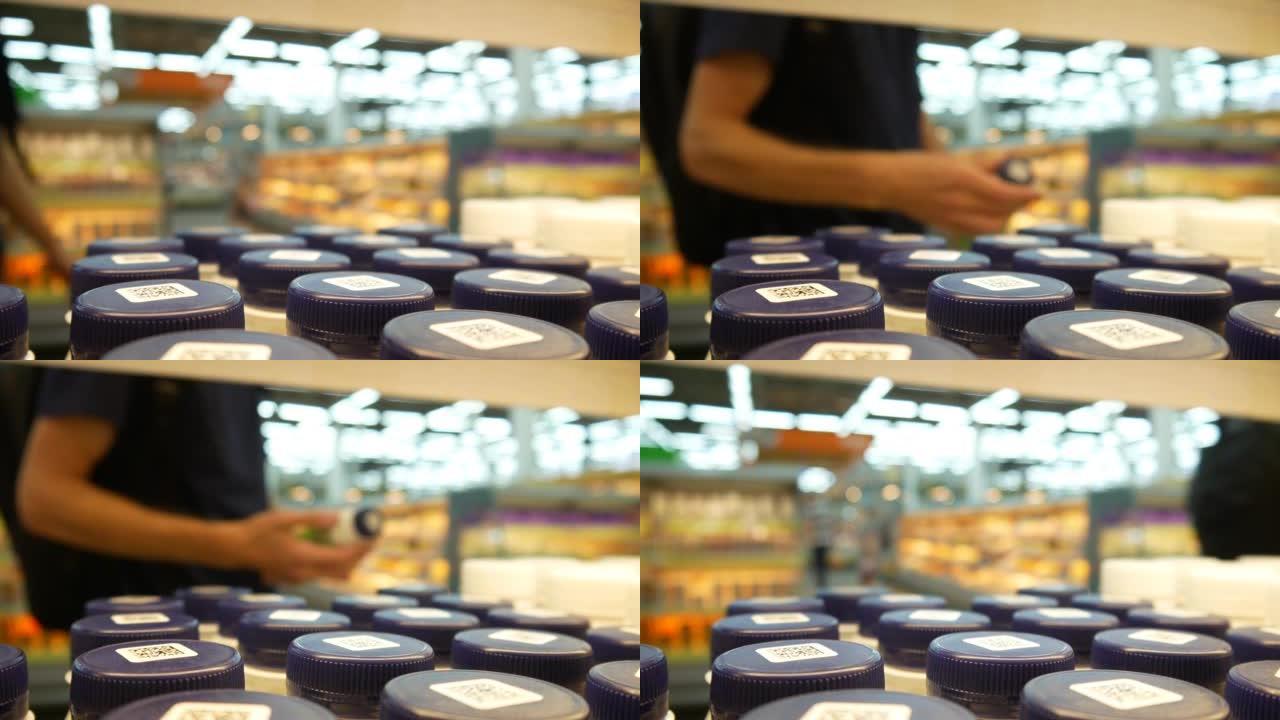 商店货架上许多带有深蓝色瓶盖的酸奶的特写镜头，一个男性买家拿了一个