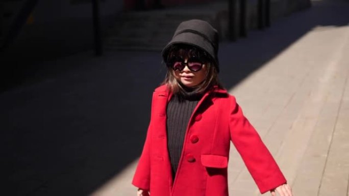 穿着红色外套的时尚韩国女婴在春天走在街上