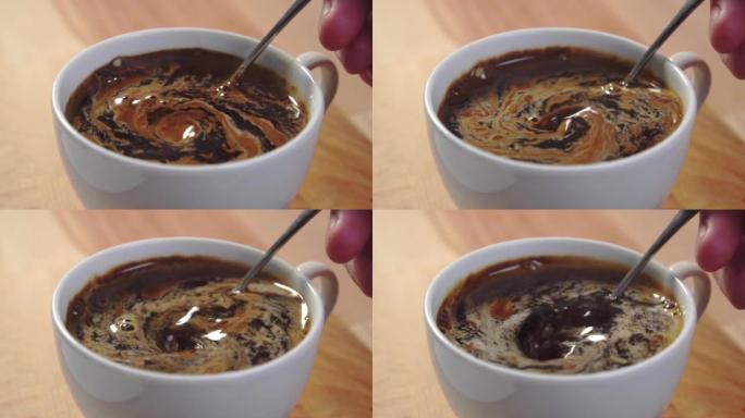 用茶匙在木桌上的白杯中搅拌速溶咖啡。溶解粉末
