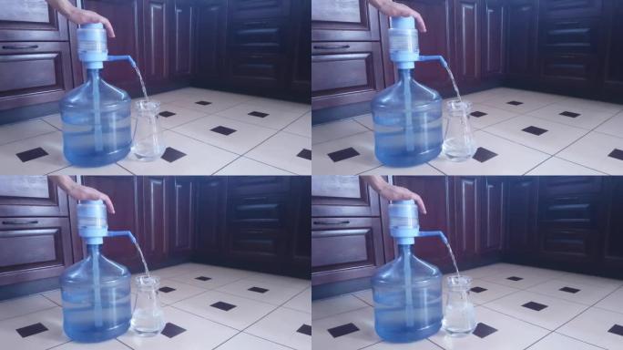 在家中用手动泵从19升塑料瓶中装满饮用水的玻璃壶