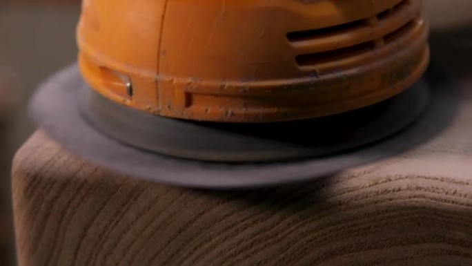 车间用轨道砂光机打磨木桌的木匠特写