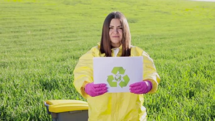 身穿工作服的人拿着纸，在日落时站在绿色的田野上，呼吁拯救地球。不良生态与环境保护的概念