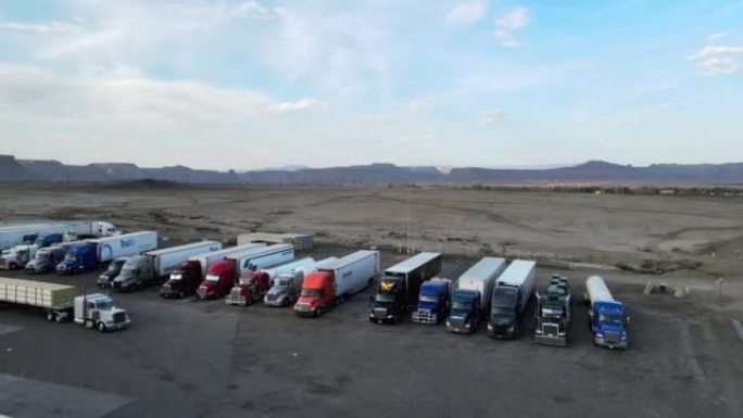 黄昏时分，空中无人机将半卡车停在犹他州东部沙漠的一个大卡车停靠处