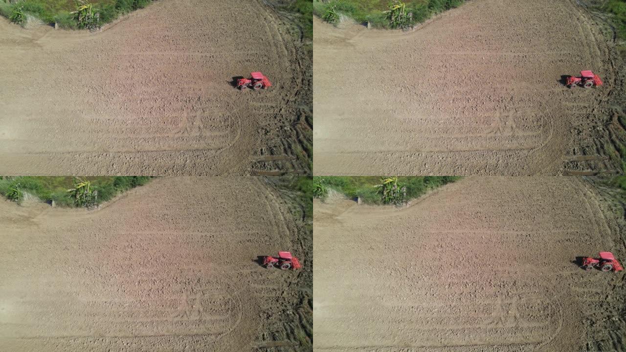 农民使用农业机械耕种田地的鸟瞰图。