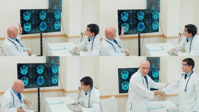 两名白人男性医生在监视器电脑屏幕上分析和讨论的4k镜头。他们在医疗中心聊天。