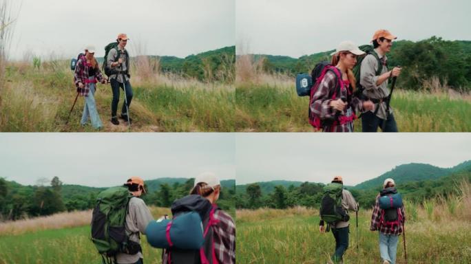 快乐的年轻夫妇徒步旅行者走过一片干燥的草地。年轻的男人和女人一起享受美好的时光。