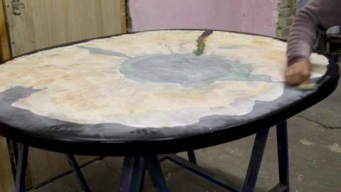 木匠用亚麻籽油涂覆木质环氧桌子