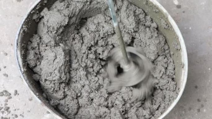 混凝土砂浆的搅拌。建筑商使用建筑搅拌机准备水泥砂浆。水桶中的石膏砂浆。