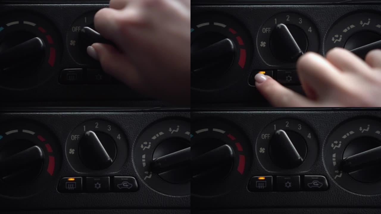 女人打开风扇，按下车内的车窗加热按钮。汽车面板特写。