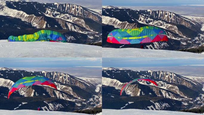 滑翔伞在覆盖着针叶林的雪白斜坡的背景下，随风向上奔跑并抬起滑翔伞的翅膀。