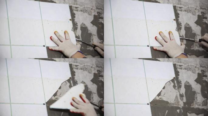 工人从厨房的墙壁上拆除了旧瓷砖。在公寓里修理，复制文本空间。工业