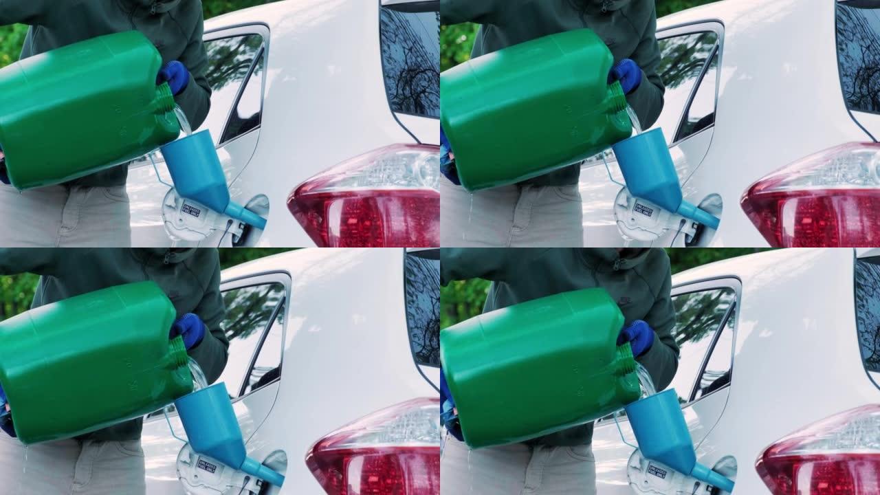 一名男子从塑料红色汽油罐将汽油倒入空油箱。将汽车从罐中注入油箱的颈部。