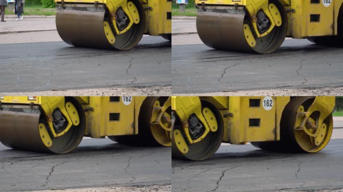 黄色压路机在铺设沥青时在路上行驶