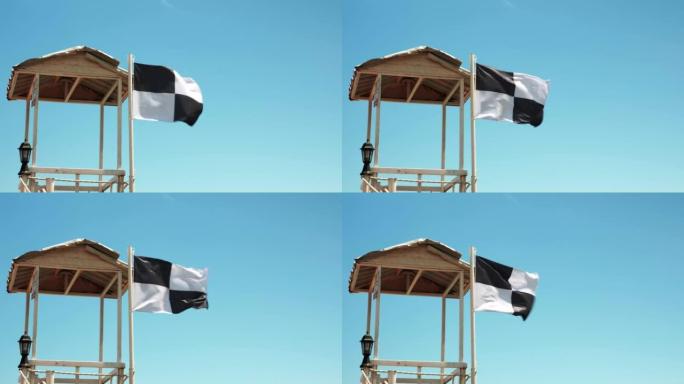 水上运动区悬挂旗帜，禁止在海上游泳。旗帜在风中飘扬。海上沙滩上的安全与风险。危险的安全区域。海滩上的