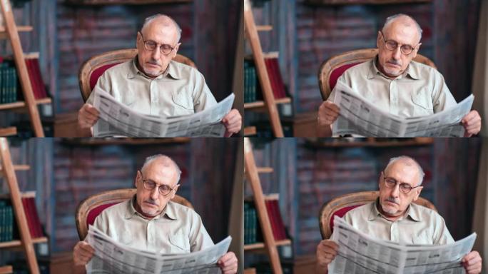 沉思的70年代成熟的祖父在老式扶手椅上阅读纸质出版物报纸文本杂志