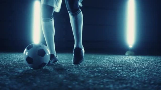 足球运球练习，职业足球运动员夜间在体育场的特写镜头，训练