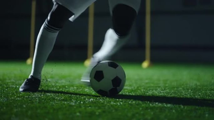 职业足球运动员在足球场上训练假人和假人，腿和球的特写镜头
